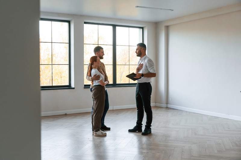 Woman and man meet agent in a vacant home.